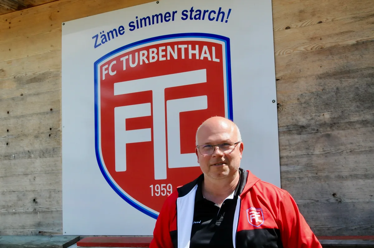 Thomas Bürgis, Präsident des FC Turbenthal, vor der Vereinstafel.